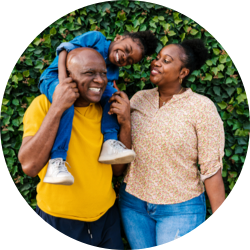 Dad carries his daughter on his shoulders, while the mother stands next to them.